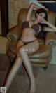 A woman in a bikini sitting on a chair.