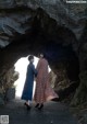 Two women standing in front of a cave. 