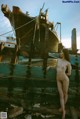 A naked woman standing next to a boat on the beach.