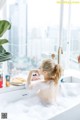 A woman sitting in a bathtub with a plate of food.