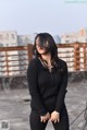 A woman standing on top of a roof next to a building.