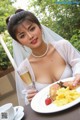 A woman in a wedding dress holding a plate of food and a glass of champagne.