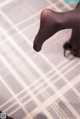 A close up of a woman's feet on a rug.