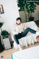 A woman sitting on a white couch in a room.