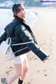 a woman walking on the beach with a backpack