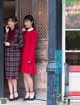A couple of women standing next to each other in front of a door.