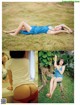 A woman in a blue bathing suit laying on the grass.